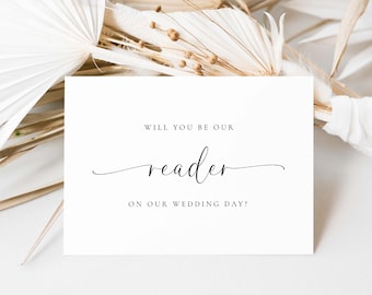 Könnte beinhalten: Eine weiße Karte mit dem Text "WILL YOU BE OUR reader ON OUR WEDDING DAY?" in eleganter schwarzer Schrift. Die Karte ist von getrockneten, beigefarbenen Zierpflanzen umgeben, die einen weichen, neutralen Hintergrund bilden.