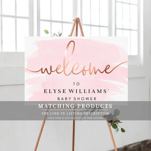 May include: Welcome sign with a pink watercolor background and gold lettering. The sign says "Welcome to Elyse Williams' Baby Shower. Matching Products See link in listing description (This item is not included in this listing)"