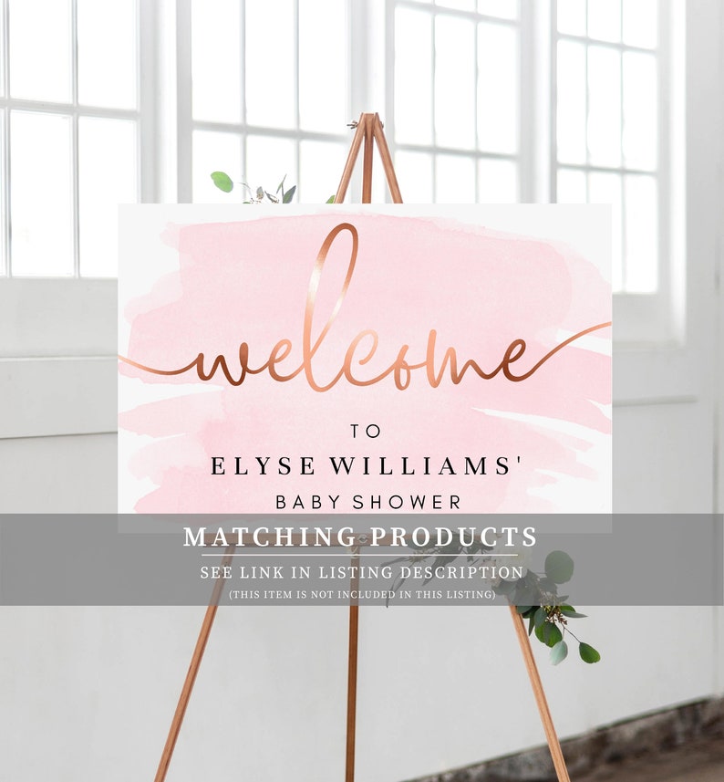 May include: Welcome sign with a pink watercolor background and gold lettering. The sign says "Welcome to Elyse Williams' Baby Shower. Matching Products See link in listing description (This item is not included in this listing)"