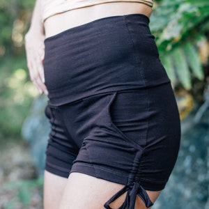 May include: Dark brown shorts with a high waistband and side pockets. The shorts have a drawstring detail at the leg opening. The shorts are made of a soft, stretchy fabric.