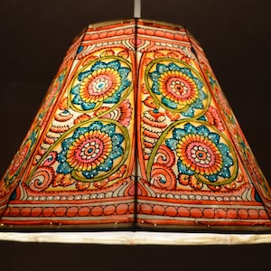 Könnte beinhalten: Ein farbenfroher, handbemalter Lampenschirm mit geometrischem Design, das florale Muster in den Farben Rosa, Blau, Gelb und Grün aufweist.