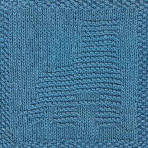 May include: A blue knitted dishcloth with a geometric pattern. The cloth is made with a simple stitch and has a square shape.