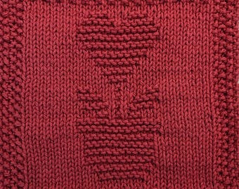May include: A red knitted dishcloth with a geometric pattern in the center.