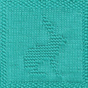 May include: Close-up of a knitted square in a vibrant teal color. The knitting pattern features a stylized, geometric design in the center. The edges have a textured border, adding visual interest to the textile.