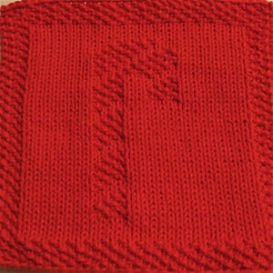 May include: Red knitted dishcloth with a cross pattern in the center.