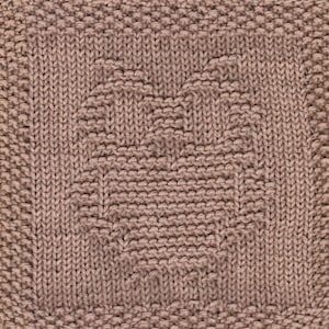 May include: A close-up of a knitted square with a textured pattern in a light brown color.