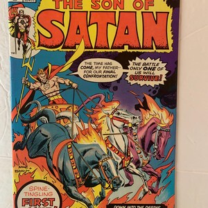 May include: A vintage comic book cover for "The Son of Satan" features a dynamic illustration. The title is in large orange letters. The artwork depicts a muscular figure in a chariot pulled by fiery horses, with flames and a dramatic sky.