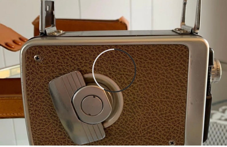 May include: A vintage silver and brown camera with a leather covering and a silver winding knob.