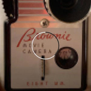 May include: A vintage black and white Bell & Howell movie camera with a red inscription that reads "Bell & Howell Movie Camera Eight MM."