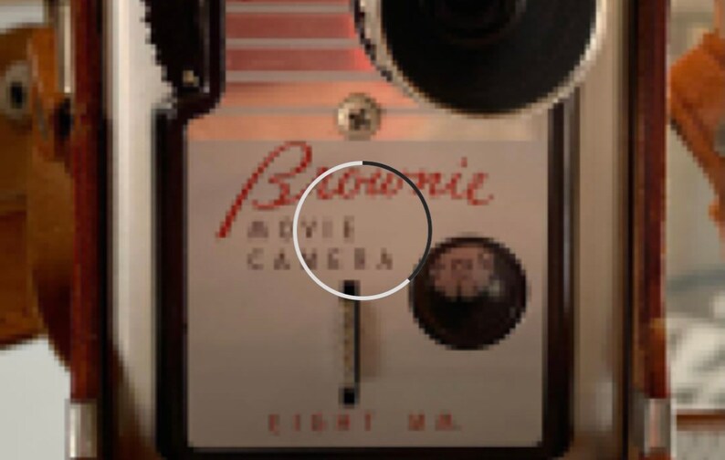 May include: A vintage black and white Bell & Howell movie camera with a red inscription that reads "Bell & Howell Movie Camera Eight MM."