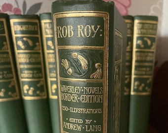 Op de afbeelding: Een groen hardback boek getiteld "Rob Roy" met gouden letters en illustraties. Het boek maakt deel uit van de Waverley Novels Border Edition, bewerkt door Andrew Lang en bevat 250 illustraties.