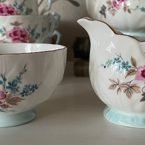 Vintage Aynsley Milk Jug/Creamer and Sugar Bowl in Crocus Shape.  Pretty Pastel Pink and Blue Floral Pattern on White Background.