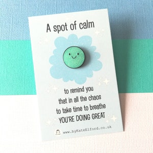 May include: A green glitter smiley face on a blue cloud with the text "A spot of calm to remind you that in all the chaos to take time to breathe YOU'RE DOING GREAT www.byKateElford.co.uk"