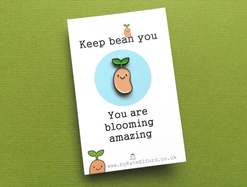 May include: A white card with the text "Keep bean you" and a cartoon bean sprout with a smiling face. The card also says "You are blooming amazing" and includes a website address.