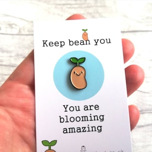 May include: A white card with the text "Keep bean you" and "You are blooming amazing". A cartoon bean sprout with a smiling face is in the center of the card.