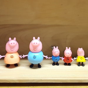 May include: A set of nine plastic figurines, including a yellow rabbit, a pink pig, and a blue pig. The figurines are all wearing different colored clothes and have different facial expressions.