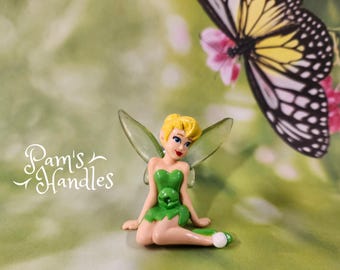 La fée clochette assise sur le côté 1b