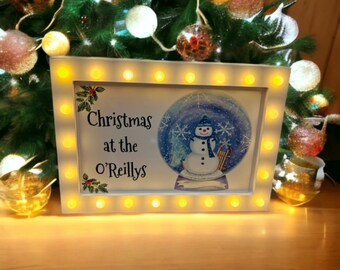 May include: White light-up sign with a snowman in a snow globe and the text "Christmas at the O'Reillys".