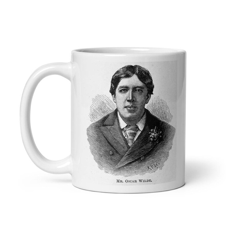 Pu&ograve; includere: Una tazza in ceramica bianca con un'illustrazione in bianco e nero di Oscar Wilde. La tazza ha un manico e il testo "Mr. Oscar Wilde" &egrave; stampato sul fondo.