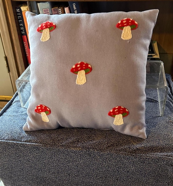 Kitschy cute mushroom pillow on denim fabric