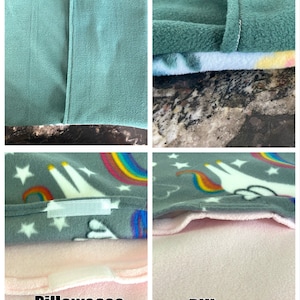 K&ouml;nnte beinhalten: Ein Kissenbezug aus Fleece mit grauem Hintergrund und einem Muster aus wei&szlig;en Einh&ouml;rnern, Regenb&ouml;gen und Sternen. Die Unterseite zeigt einen Hotelverschluss, w&auml;hrend das Innere ein hellrosa, nicht saugf&auml;higes Futter mit Klettverschluss aufweist.