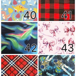 K&ouml;nnte beinhalten: Eine Collage aus zehn Stoffmustern, nummeriert von 38 bis 47. Die Muster umfassen schwarz-wei&szlig;es Karomuster, Regenbogen-Tie-Dye, bunte Dinosaurier auf Blau, rot-schwarzes Schottenmuster, Nordlichter, rosa Schleifen, rotes Schottenmuster, Astronauten im Weltraum, rosa Punkte und Federn.