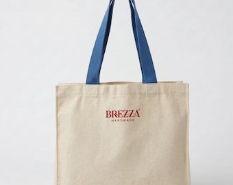 Bolsa de ombro grande, com fole e bolso interno, em lona gabardine crua feita à mão.