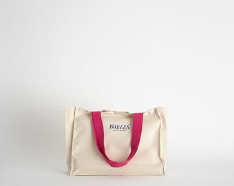 Bolsa de ombro grande com reforço lateral e bolso interno, feita à mão em lona gabardine crua.