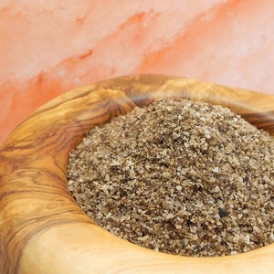 May include: A close-up of a wooden bowl filled with brown Himalayan salt crystals.