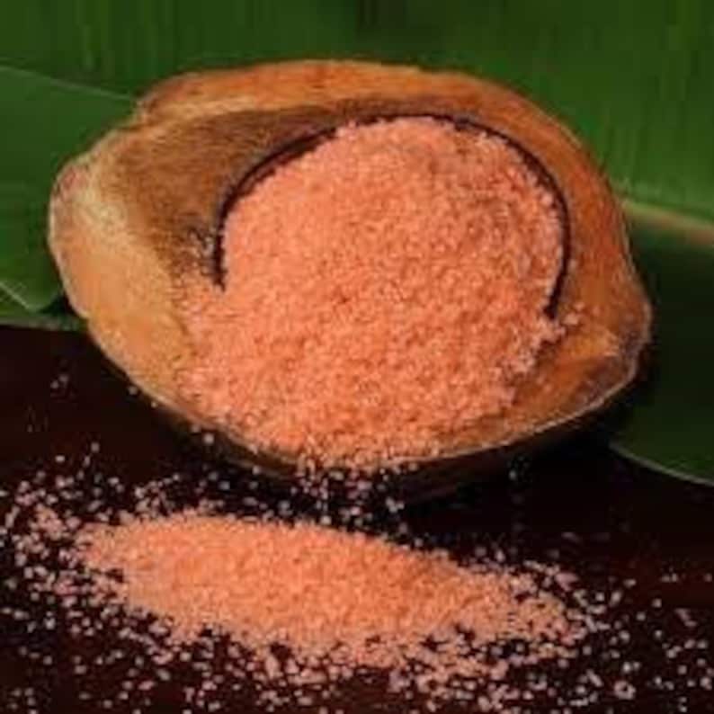 May include: A close-up of a bowl of pink Himalayan salt, a type of rock salt, in a wooden bowl. The salt is coarse and granular.