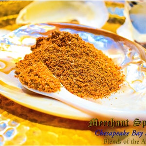 Puede incluir: Primer plano de una pequeña cuchara blanca llena de condimento marrón Chesapeake Bay, una mezcla de especias de las Américas, de Merchant Spice Co.
