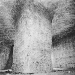 K&ouml;nnte beinhalten: Ein Schwarzwei&szlig;foto eines gro&szlig;en, grob behauenen Steinpfeilers in einem h&ouml;hlenartigen Raum. Der Pfeiler ist hoch und breit, und die umliegenden W&auml;nde sind rau und uneben.