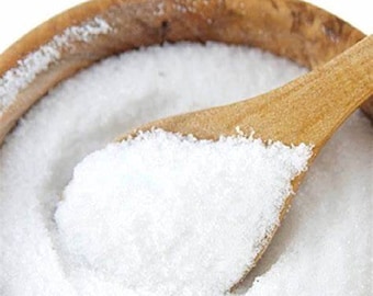 May include: A wooden bowl filled with white granulated salt, with a wooden spoon scooping out some of the salt.