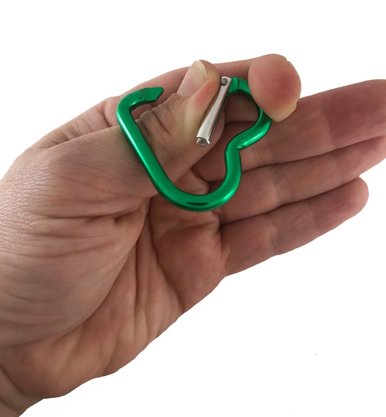 May include: A green metal carabiner with a heart shape. The carabiner is open and ready to be used.