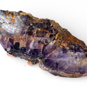 Könnte beinhalten: Ein roher Amethystkristall mit einer Mischung aus lila, braun und klarem Quarz. Der Naturstein hat eine raue, strukturierte Oberfläche und eine Vielzahl von Farben und Mustern. Ein einzigartiges Naturstück.