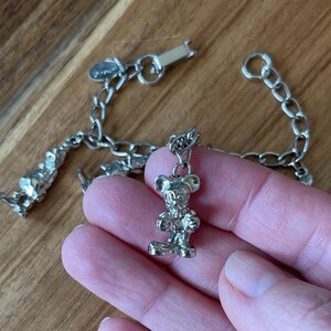 Op de afbeelding: Zilverkleurige bedelarmband met een Mickey Mouse bedel. De armband heeft een schakelketting ontwerp en een karabijnsluiting. De Mickey Mouse bedel is een gedetailleerde, driedimensionale figuur.