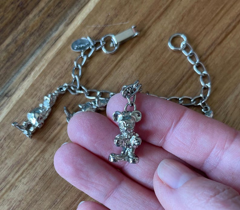 Op de afbeelding: Zilverkleurige bedelarmband met een Mickey Mouse bedel. De armband heeft een schakelketting ontwerp en een karabijnsluiting. De Mickey Mouse bedel is een gedetailleerde, driedimensionale figuur.