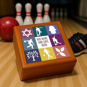 May include: A wooden keepsake box with a colorful, tiled top featuring bowling-themed graphics and the text "ADD NAME AND DATE HERE." A red bowling ball, pins, and a bowling shoe are in the background. The box is on a wooden surface.