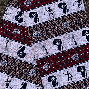 May include: White fabric with a repeating pattern of black silhouettes of people, palm trees, and the continent of Africa. The fabric also has a repeating pattern of red, black, and brown diamonds.