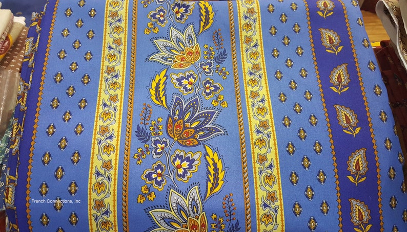 May include: Blue and yellow striped fabric with a floral pattern. The fabric has a repeating pattern of flowers and leaves in shades of blue, yellow, and orange. The fabric is made of cotton and is suitable for upholstery, curtains, and other home decor projects.