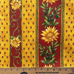 May include: Red and yellow fabric with a repeating pattern of sunflowers, olive branches, and small yellow flowers. The fabric has a textured look and feel.