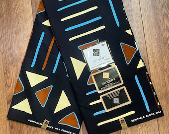 May include: Black fabric with a geometric pattern of brown, blue and cream triangles and lines. The fabric has the text "ANTIOUITY" and "VERITABLE BLOCK WAX" printed on it.