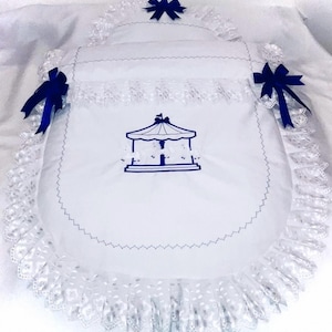 May include: White baby carriage liner with blue bows and a blue embroidered carousel design.