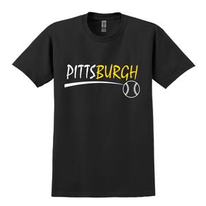 May include: Black t-shirt with a white graphic of the word "PITTSBURGH" with a yellow outline and a baseball underneath.