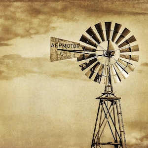 May include: A vintage black and white photo of a windmill with a sign that reads "The Aermotor Co. Chicago".