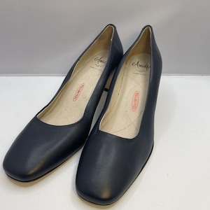 May include: A pair of black leather pumps with a square toe. The shoes have a mid-height heel and a cushioned insole with the text "PILLOW FEEL". The brand name "Amalfi" is visible inside the shoe.