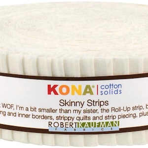 May include: A roll of off-white fabric strips, labeled "KONA cotton solids Skinny Strips." The label includes text about the strips' size and uses. The fabric is tightly wound, showing a ribbed edge.
