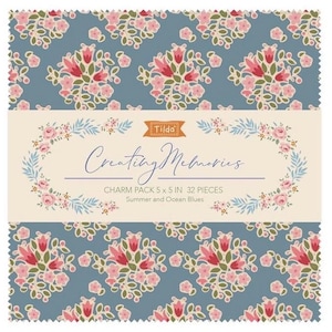 May include: A square fabric charm pack with a floral pattern in pink and red on a blue background. The text "Creating Memories" is displayed with the brand name "Tilda". Each charm measures 5 x 5 inches.