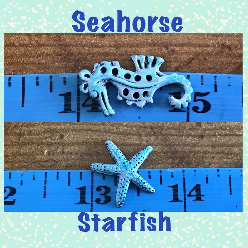 May include: A light blue seahorse and starfish, both with white accents, are displayed on a blue measuring tape. The seahorse is approximately 2 inches long. The word "Seahorse" is written above the seahorse, and "Starfish" is written below the starfish.