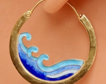 Può includere: Orecchini a cerchio in oro con onde in smalto blu e bianco. Gli orecchini sono di design semplice con una finitura in oro martellato.